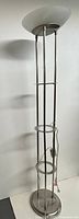 Full view of brushed steel floor lamp showing shelves and base