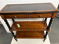 Front view of mahogany console table showing drawers, shelves and barley twist legs