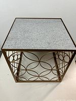 Full view of square accent table showing metal lattice base and stone top