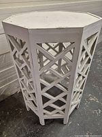 Three-quarter view of the octagonal white wood table showing lattice sides