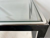 corner detail of glass top inset into polished chrome frame