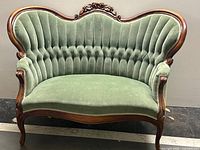 Full front view of green velvet carved wood settee