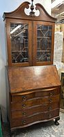 Full view of the mahogany secretary bookcase showing both upper glass cabinet and lower serpentine drawers