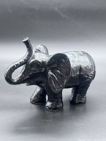 front view of black glazed ceramic elephant figurine