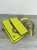 Full view of neon yellow Call It Spring handbag with chain and strap