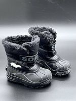 Front and side view of boots showing overall design, rubber shell, faux-fur collar, and SOREL strap