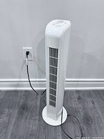Full view of white Digimark tower fan plugged in
