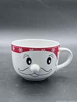 Front view showing Santa face design, molded nose, red snowflake rim and handle