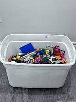 White plastic tub filled with assorted Lego pieces