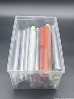 Top view of plastic bin filled with assorted taper candles