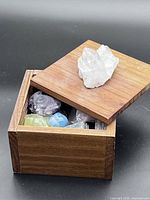 Box with lid ajar showing crystals, clear quartz cluster on lid