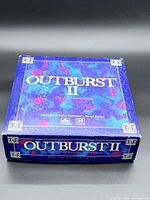 Lid of Outburst II board game showing full box