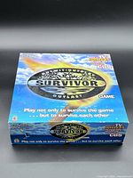 Box lid displaying Survivor Outwit Outplay Outlast graphics