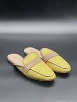 Top view of both yellow mules showing woven upper and beige straps