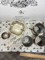 All seven silver-plate items laid out