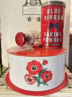 All three items grouped: cookie press parts, Blue Ribbon tin, poppy cake tin