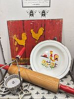 Group shot showing enamel bowl, rolling pin, cookie cutters, red rooster plaque