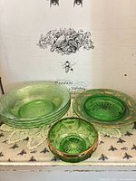 All six green pressed glass pieces grouped