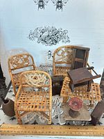 Group shot of wicker chairs, wooden tables, blocks and vase with ruler for scale