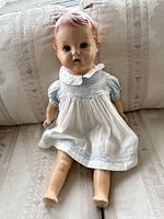 Full front view of antique bisque baby doll in dress