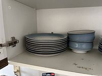 Stack of nine plates in cabinet