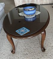 Oval coffee table showing glass top and cabriole legs
