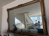 Front view of gold-framed baroque style mirror showing frame details and reflective surface