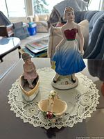 All three ceramic items: Royal Doulton figurine, piano baby in boat, floral basket