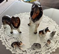 Group of six porcelain collie figurines on doily