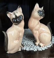 Front view of both ceramic Siamese cat figurines showing color, glaze and condition