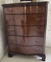 Front view showing entire tall chest with serpentine front and five drawers