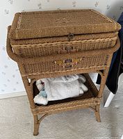 Full view of closed wicker sewing basket on stand showing front pattern and lower shelf