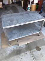 Full view of aluminum utility table showing top and lower shelf