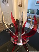 Full view of red and clear acrylic sculpture on base