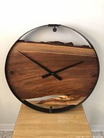 Front view of round live edge walnut clock in steel frame
