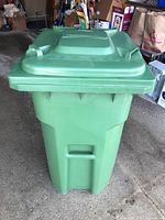 Front view of green wheeled bin with lid closed