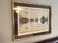Framed triptych print on wall showing full artwork and frame
