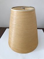 Full view of lampshade standing upright showing exterior texture and fitter ring
