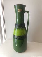 Front view of green Carstens vase with foil label visible