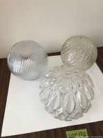 Three glass globe shades showing differing textures
