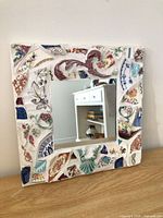 Front view of square mirror showing full mosaic frame and central glass