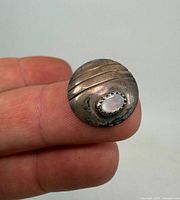 front view showing domed silver disc, grooves and opal