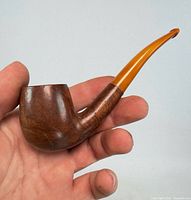 Full view of pipe in hand showing size, bowl, shank and stem