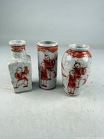 Front view of three iron red crackle-glaze porcelain bud vases