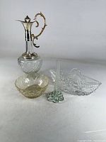 All four vintage glass items grouped: crystal claret jug, oval relish dish, amber bowl, bud vase