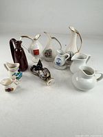 Group shot of all miniature pitchers, creamers and underplate