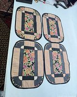 Four matching quilted floral placemats laid on table