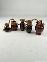 Five miniature glazed pottery vessels roped together
