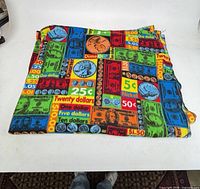 Full view of folded blanket showing money print pattern