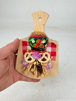 Front view of wooden cutting board wall hanging showing all decorative elements